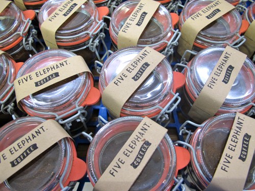 Small coffee jars getting ready for delivery to a local hostel