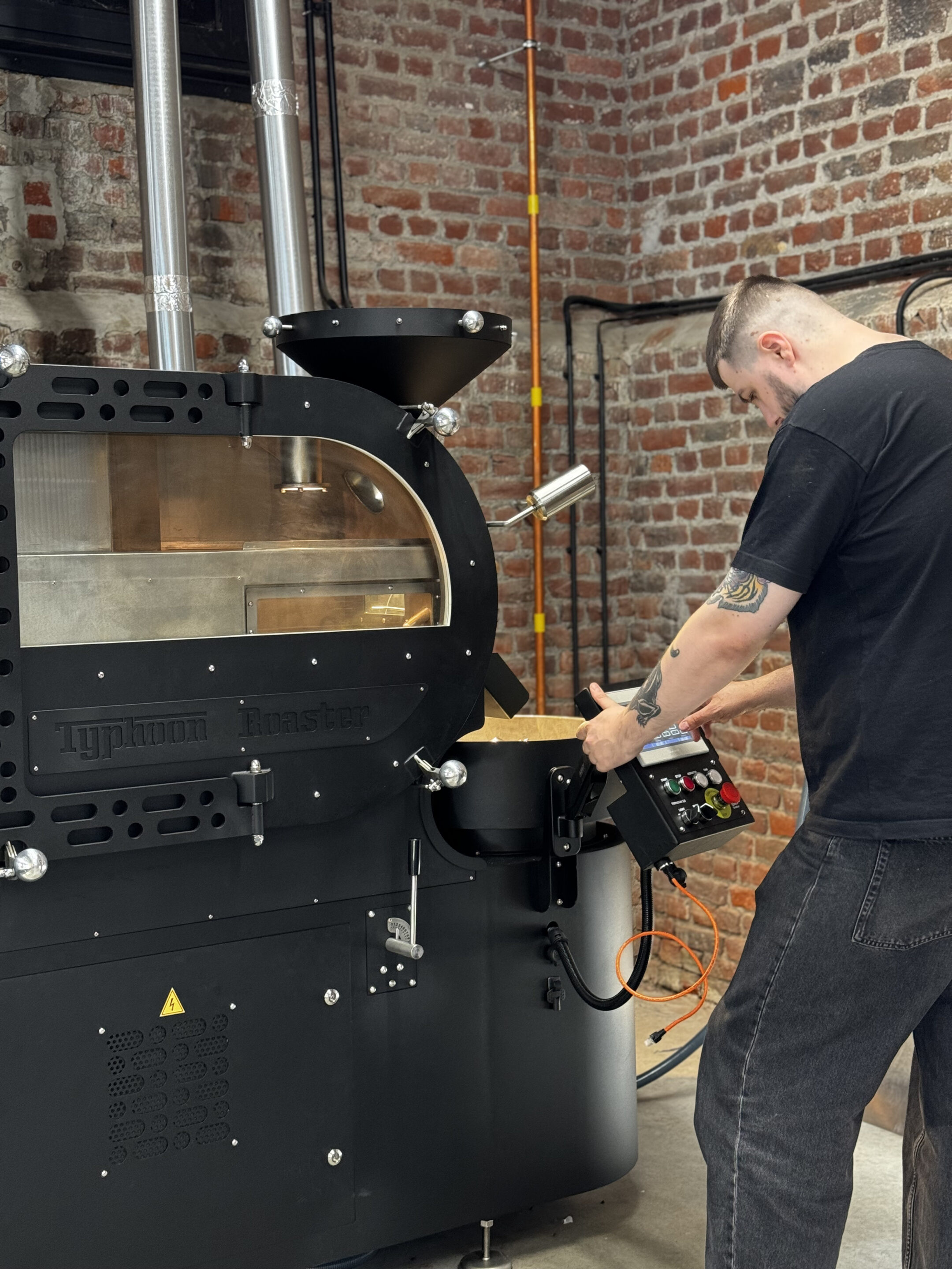 Man standing next to a coffee roaster