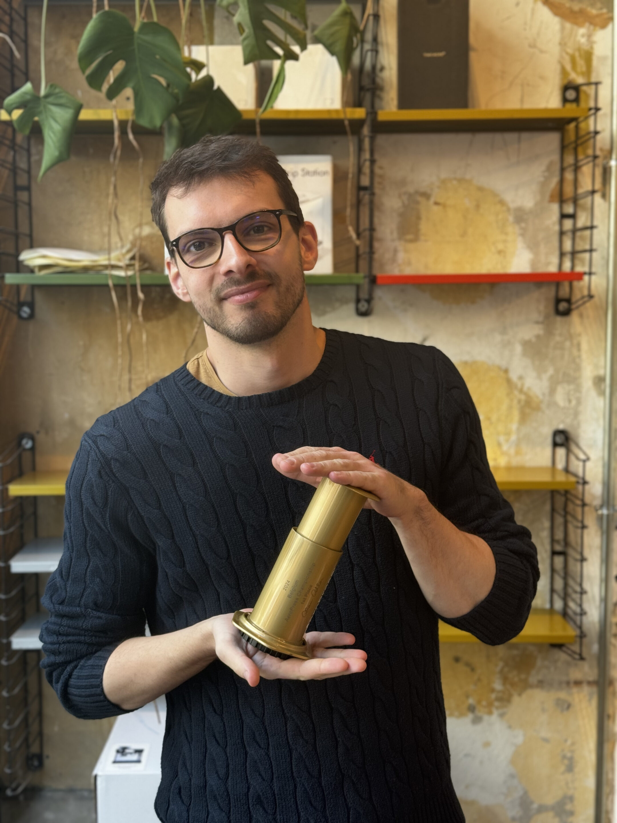 Man holding a golden Aeropress trophy