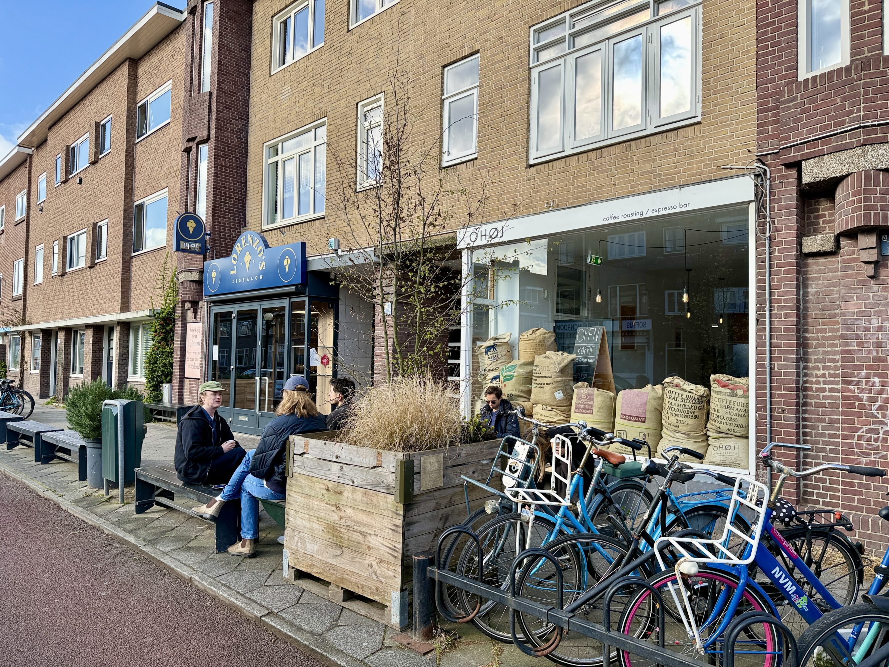 View of a residential street with bikes and chairs.