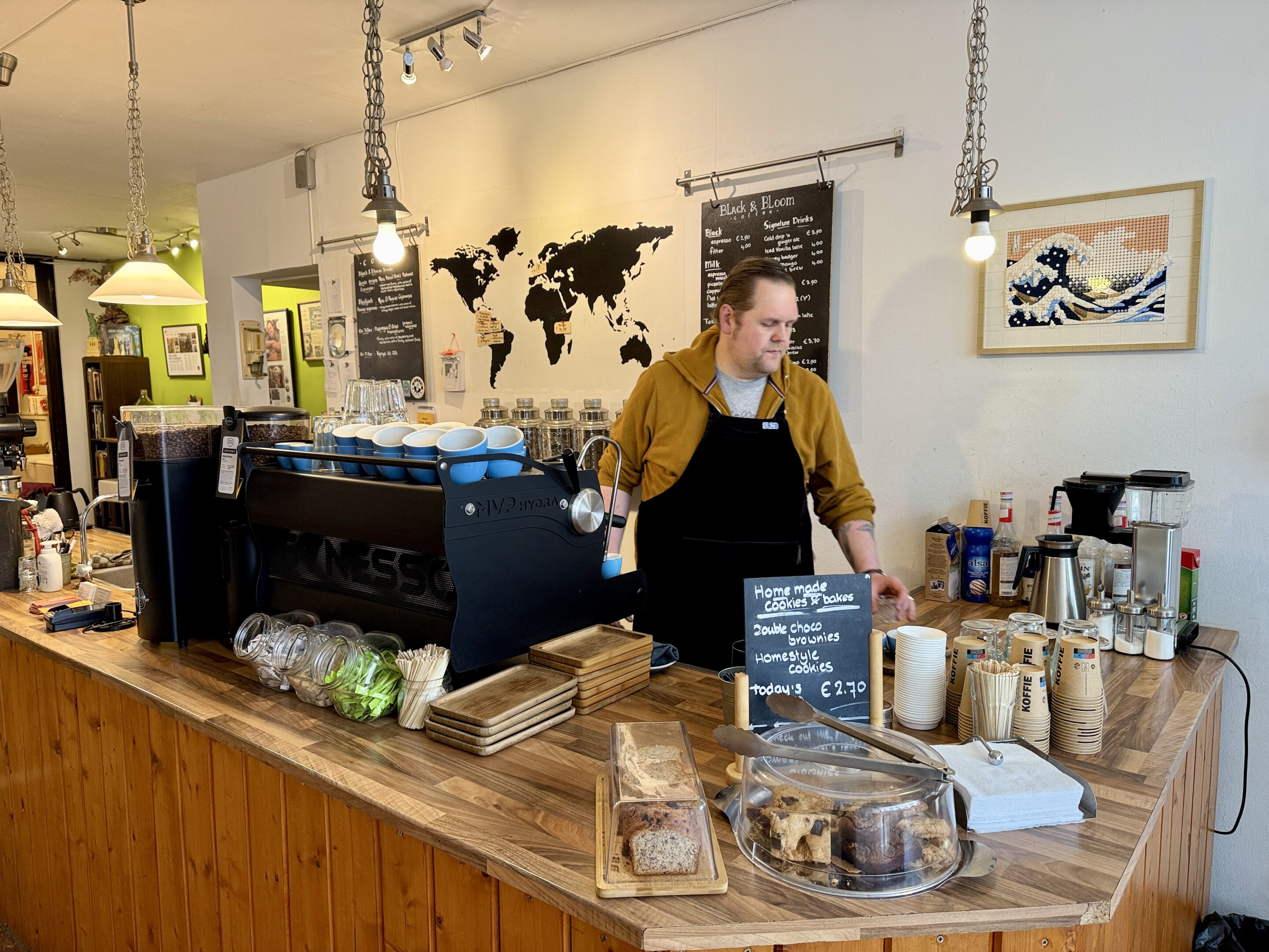 View of a coffee bar with owner behind the counter