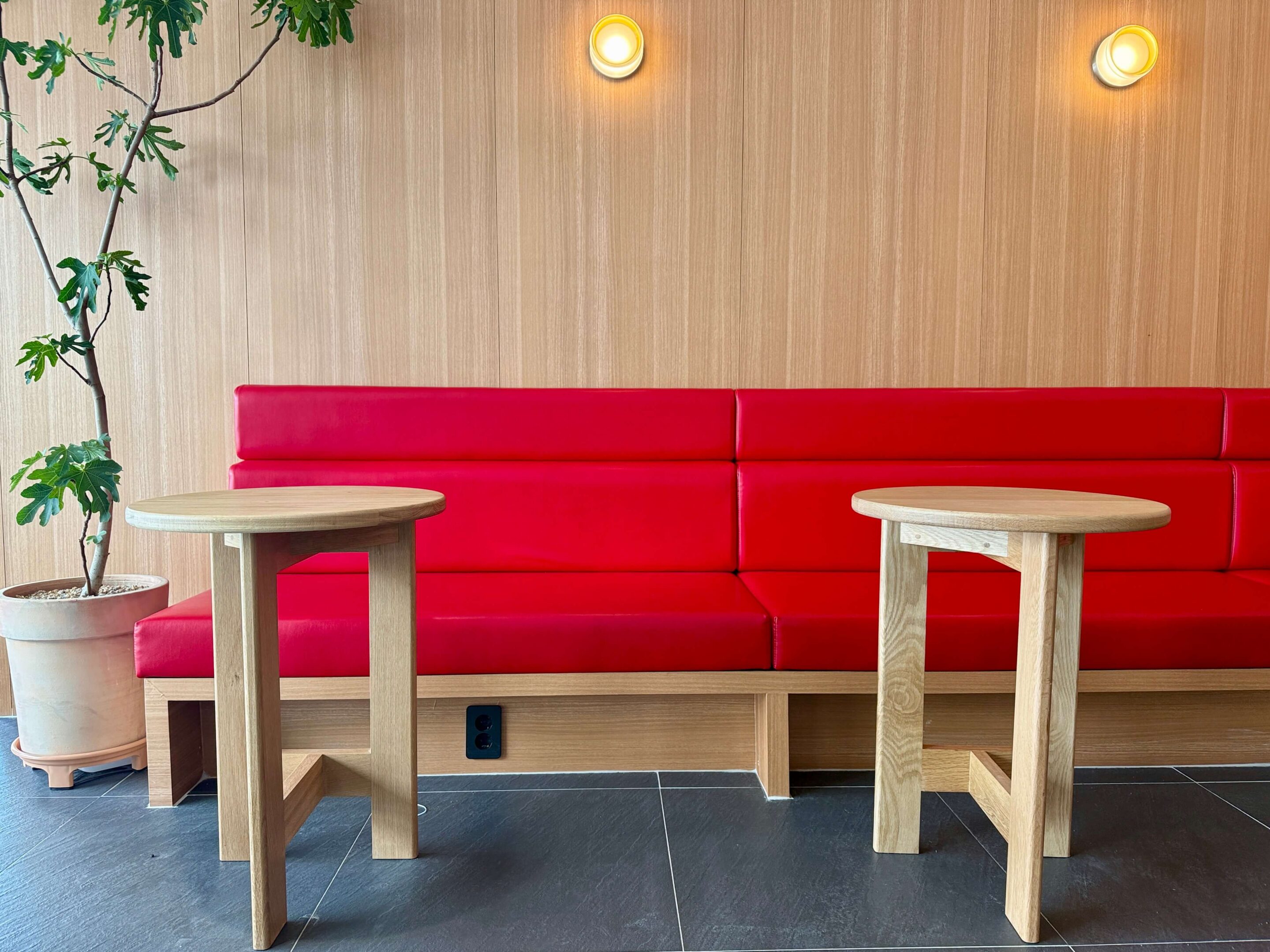 View of a red bench with two tables in front of it