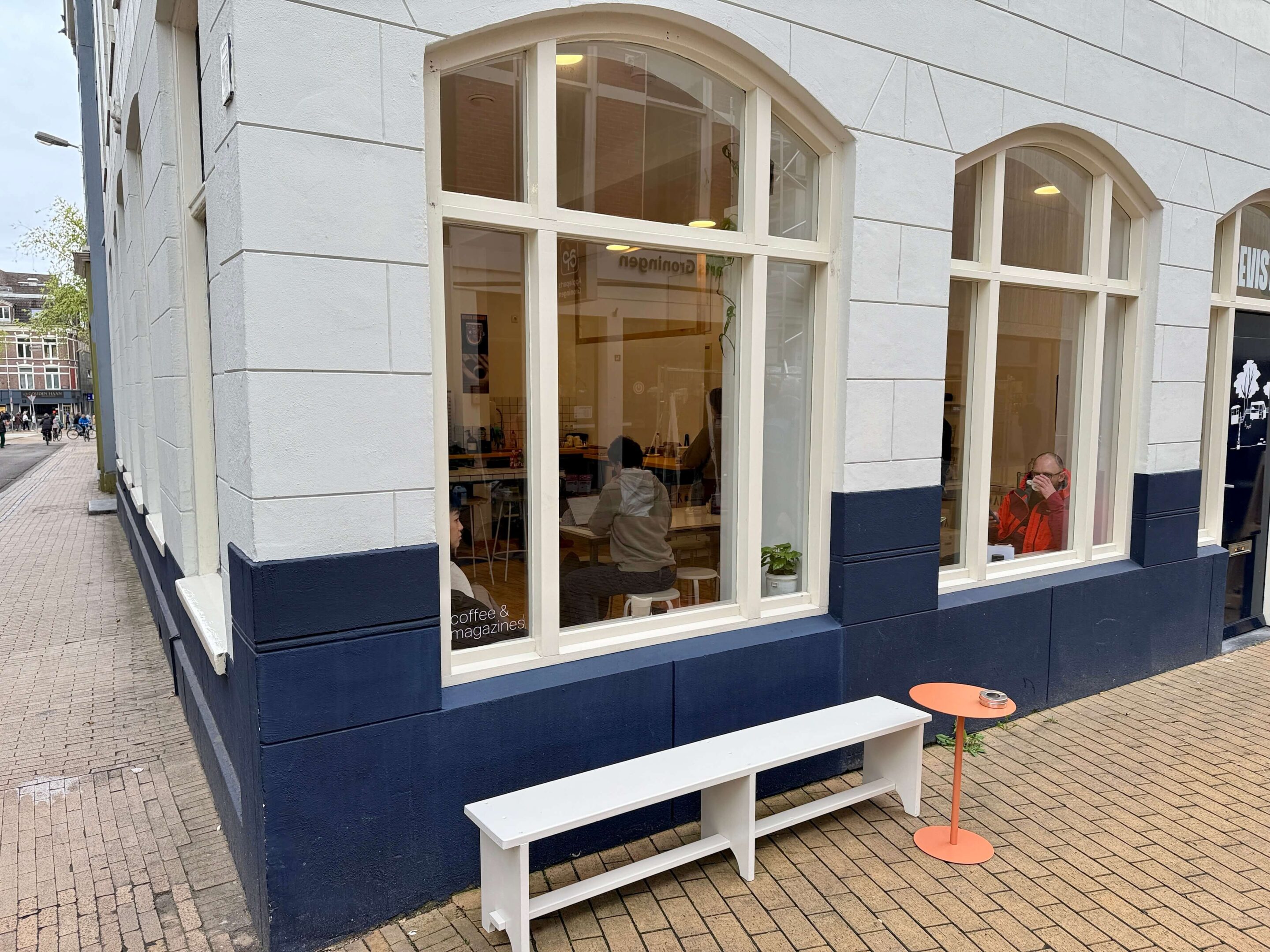 View of a corner shop with a small white bench