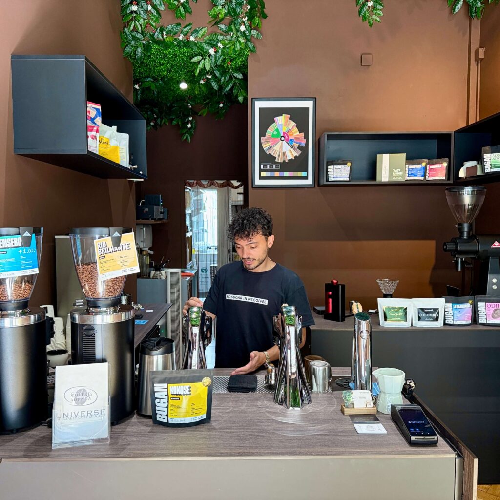 View of a coffee bar with the barista at work behind the counter