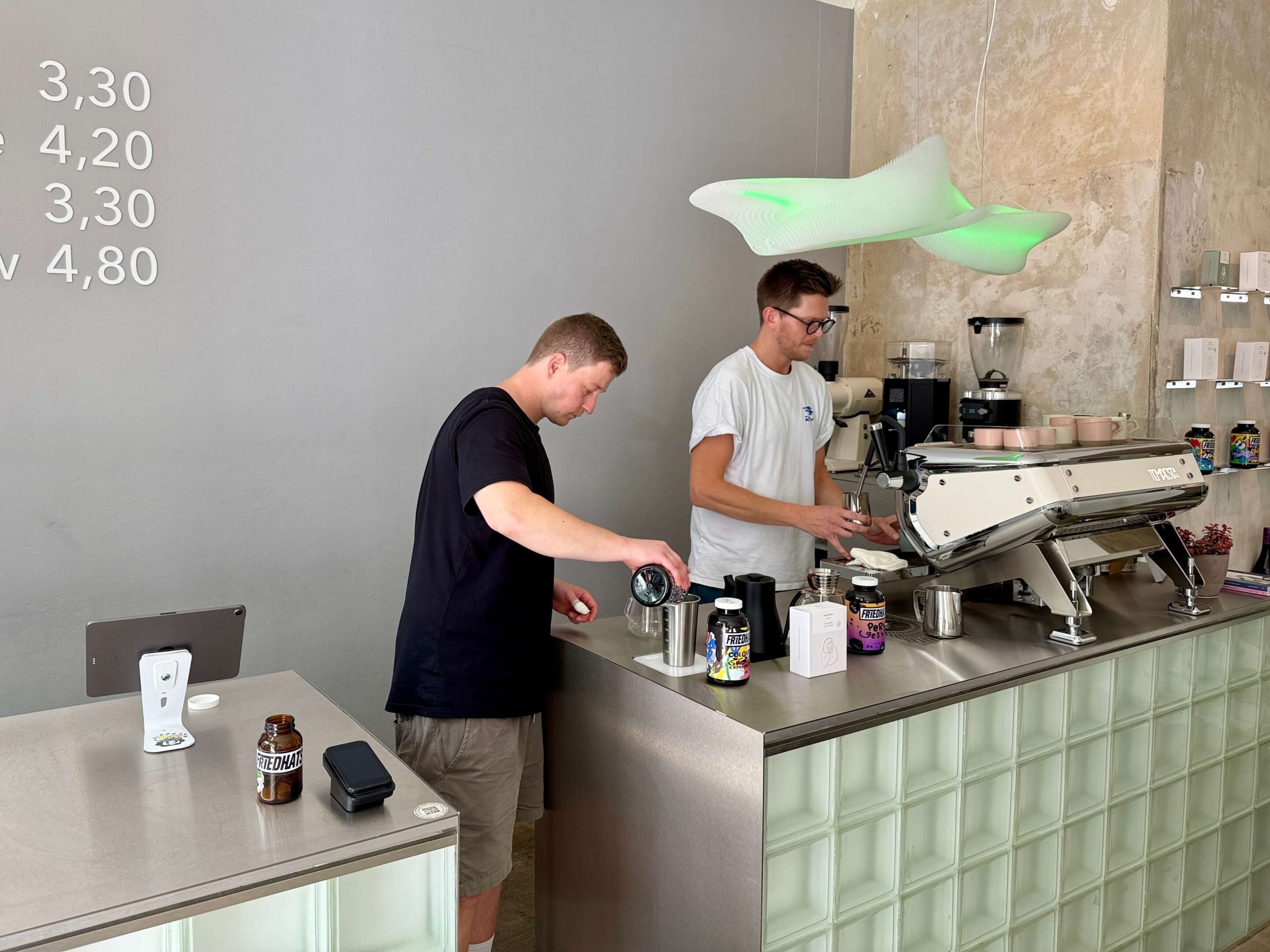 View of two baristas at work behind an espresso machine