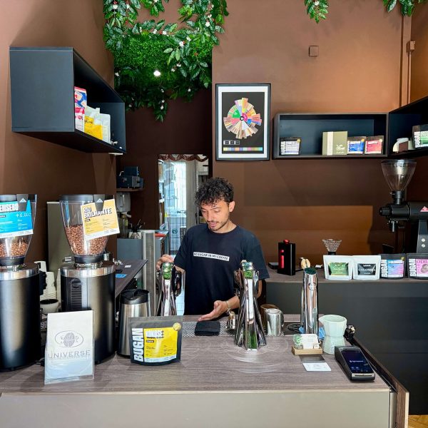 View of a coffee bar with the barista at work behind the counter