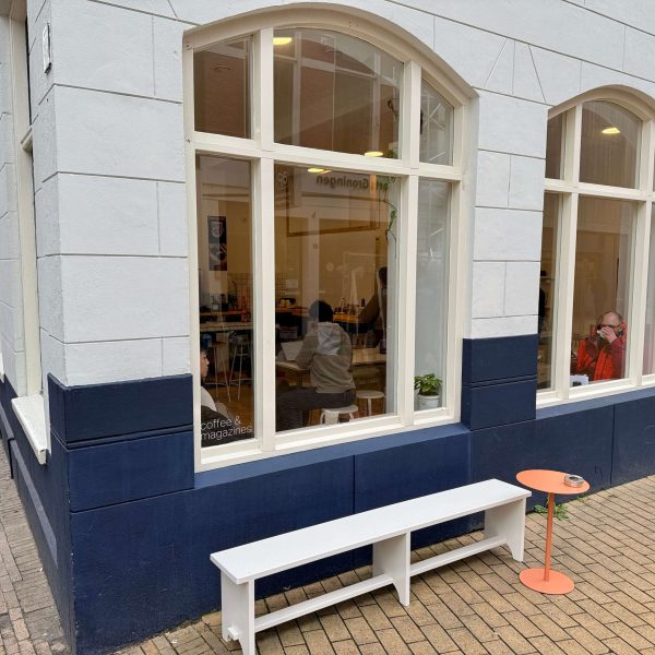 View of a corner shop with a small white bench